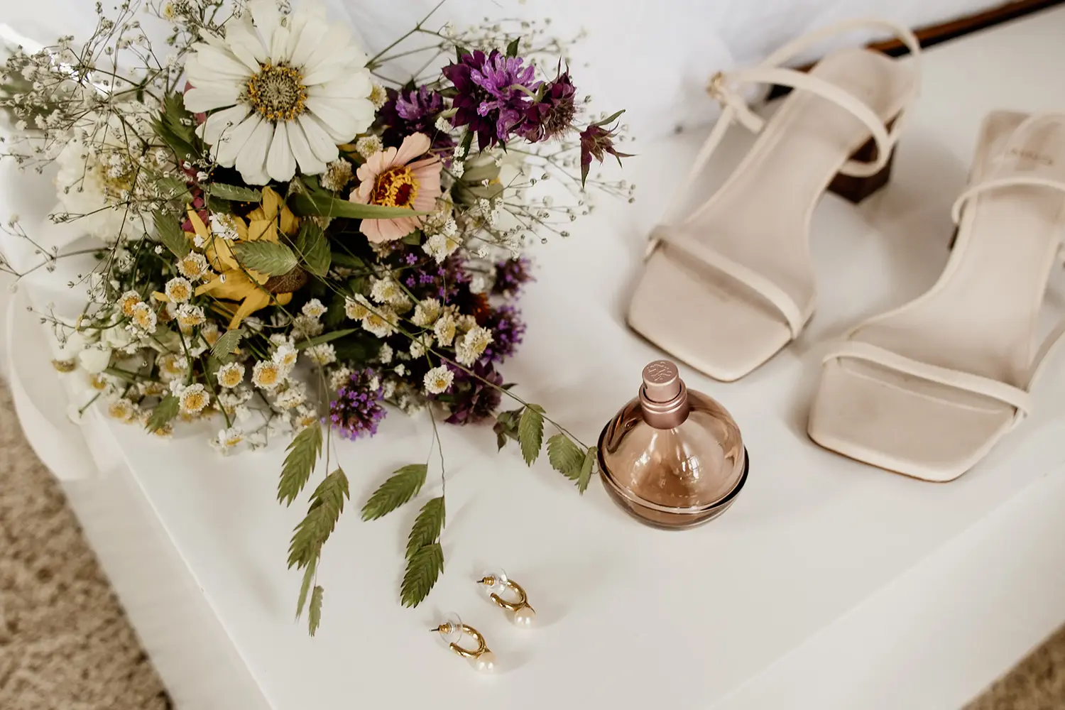 Detalles de ramo, zapatos y perfume