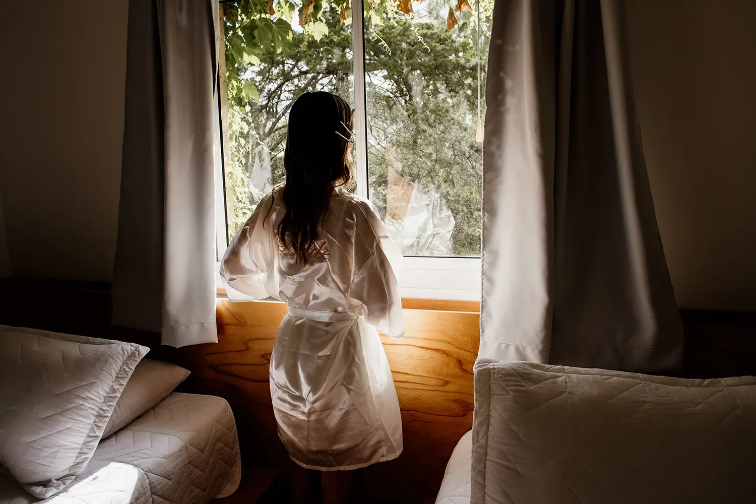 Novia mira el civil desde la ventana de su habitación en sus preparativos