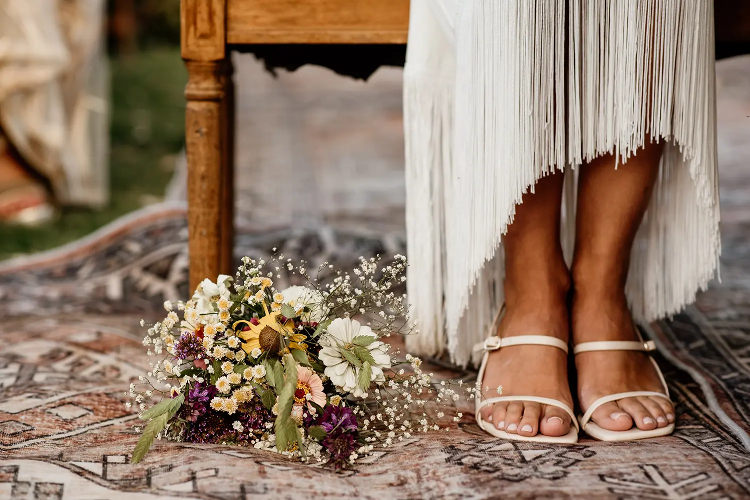 Detalle de ramo junto a pies de la novia
