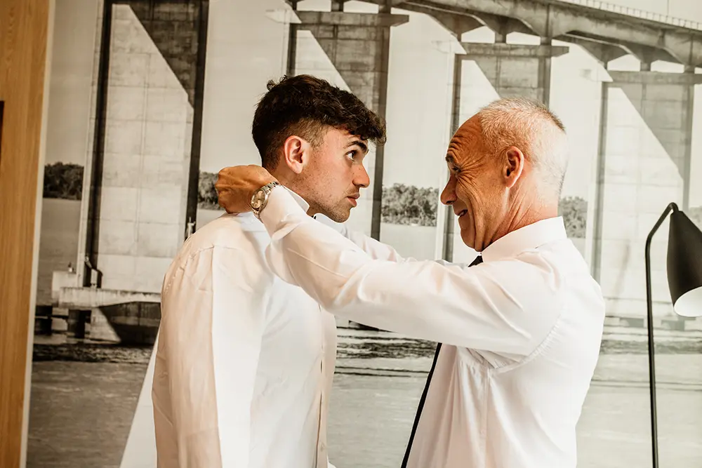 El padre le acomoda la camisa al novio