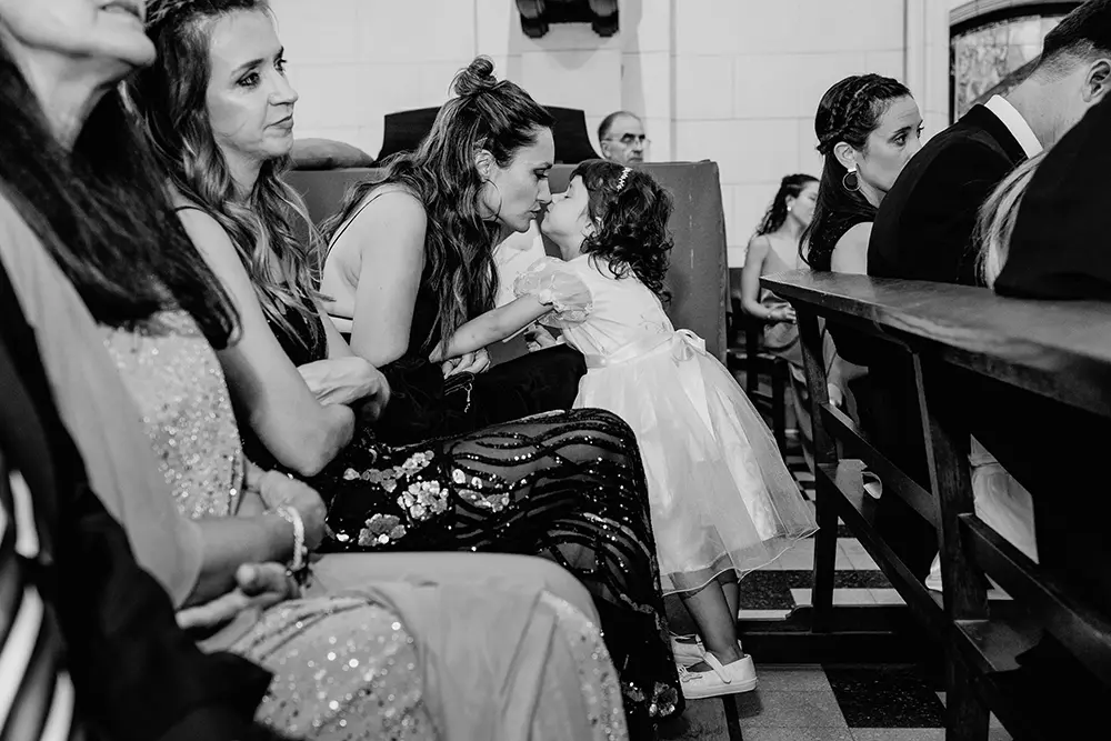Sobrina le hace mimos a su mamá en la ceremonía