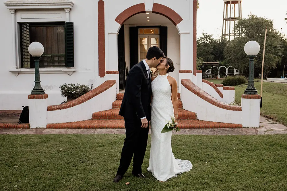 Novios se besan con la casona al fondo