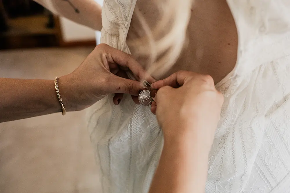 Las amigas de la novia le colocan una medalla en el vestido