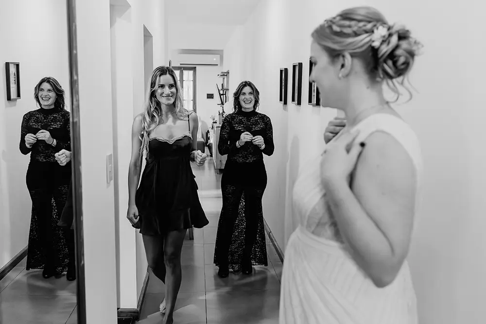Las amigas de la novia la ven mientras se mira al espejo