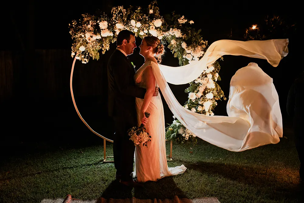 Retratos de novios a contra luz con el vestido volando