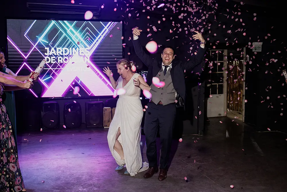 Entrada de novios al salón amigos les tiran pétalos de rosas