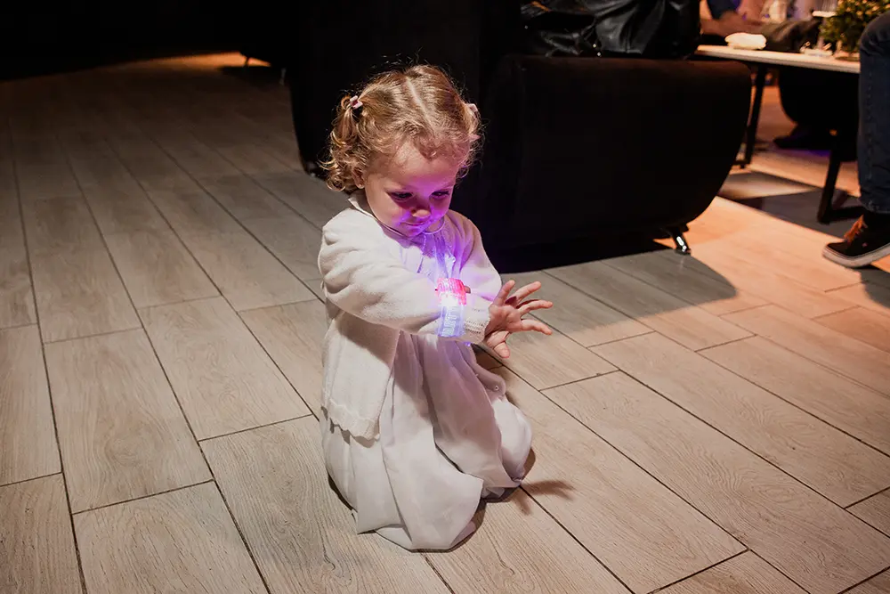 Niña se pone la pulsera y la mira asombrada